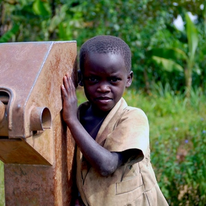 Un enfant noir s'appuie contre une pompe à eau - Rwanda  - collection de photos clin d'oeil, catégorie portraits